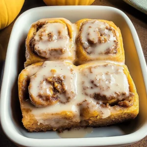 Homemade pumpkin chai cinnamon rolls topped with cinnamon icing.