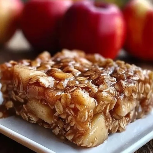 A delicious slice of apple cinnamon baked oatmeal topped with fresh apples and cinnamon.