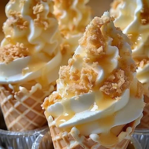 Banana pudding cheesecake cones topped with whipped cream and slices of banana
