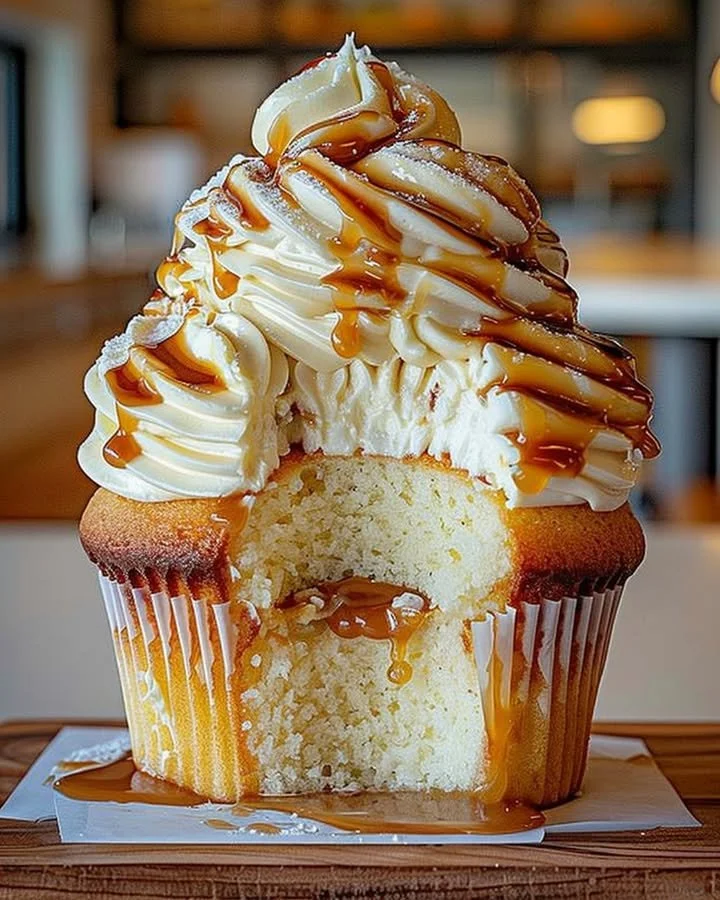 Delicious caramel cupcake with cream cheese frosting on a decorative plate.