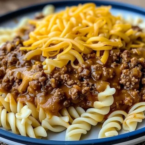 Plate of cheesy sloppy cheeseburger pasta topped with cheese and herbs