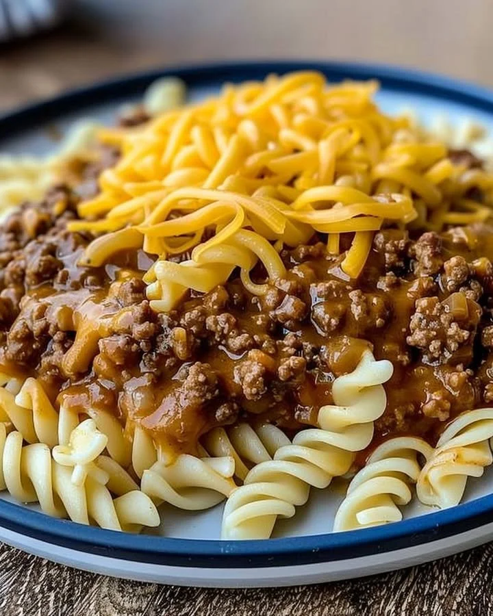 Plate of cheesy sloppy cheeseburger pasta topped with cheese and herbs