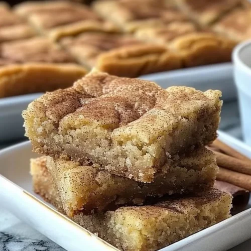 Chewy snickerdoodle cookie bars stacked on a plate