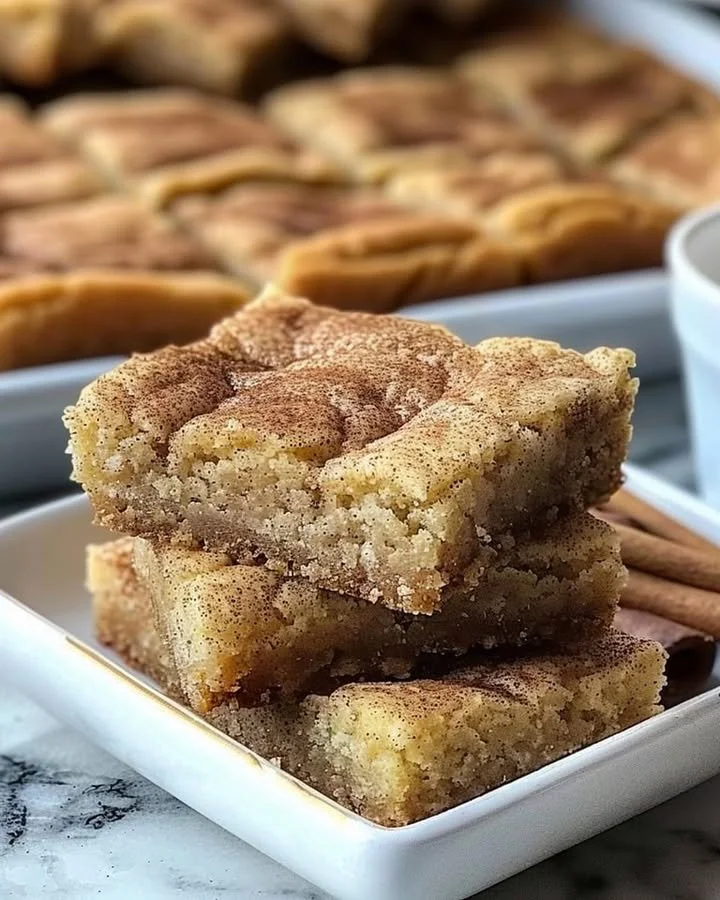 Chewy snickerdoodle cookie bars stacked on a plate