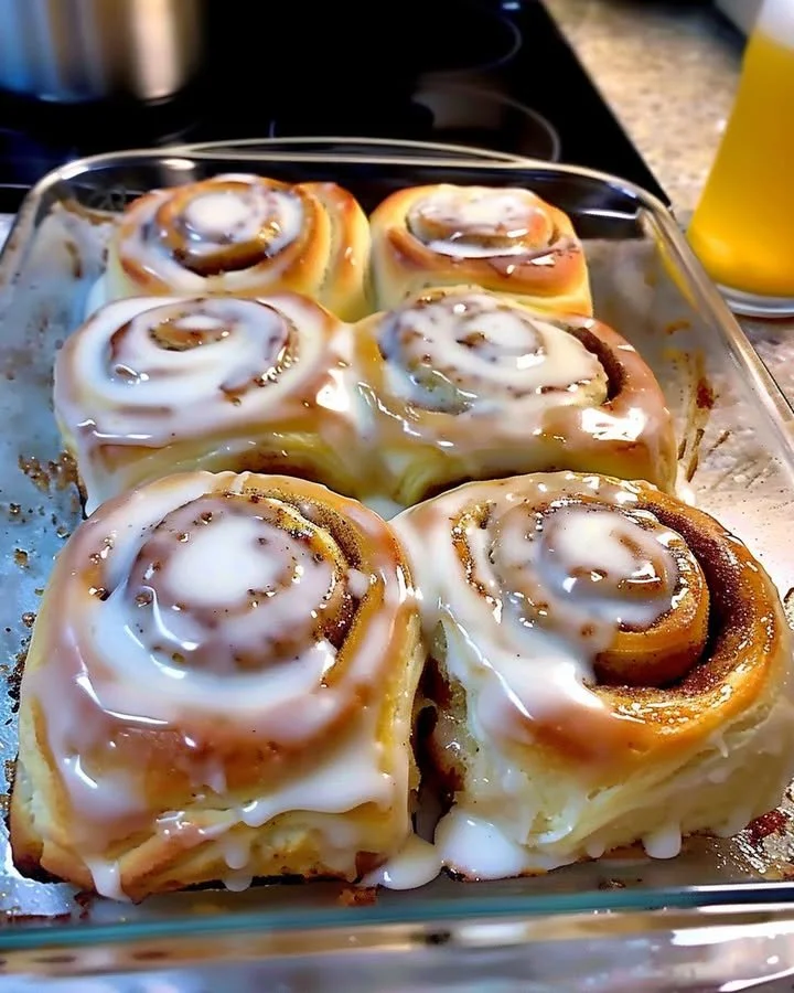 Delicious classic cinnamon rolls topped with icing on a plate