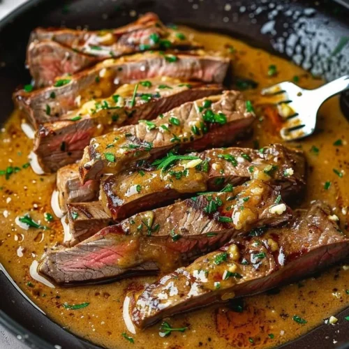 Delicious pan-seared steak garnished with herb butter on a plate