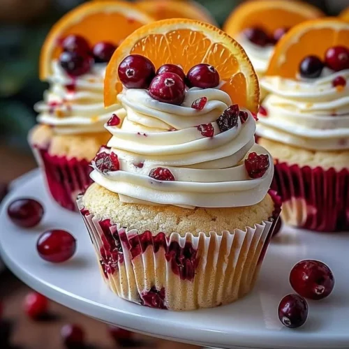 Cranberry Orange Cupcakes topped with white chocolate frosting and fresh cranberries