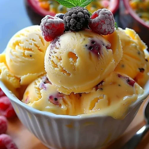 Creamy passion fruit ice cream in a bowl topped with fresh fruit