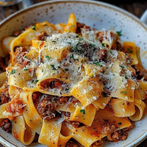 Creamy Calabrian Chili Pappardelle with sausage and fennel atop a wooden table