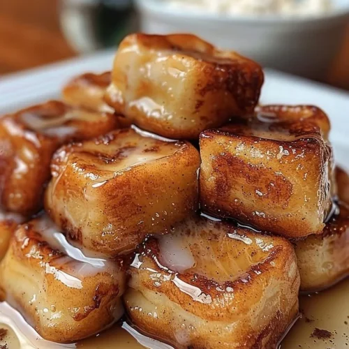 Crispy cinnamon roll French toast bites topped with sweet maple glaze