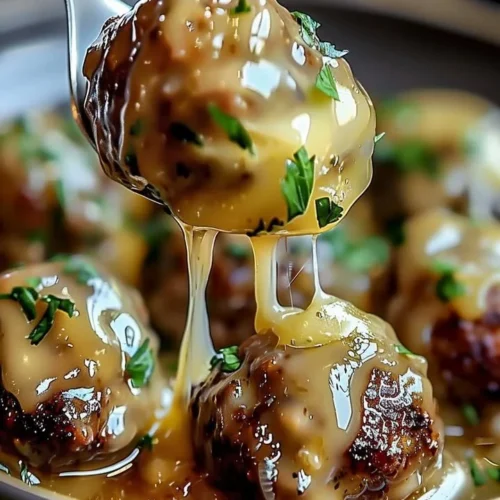 Delicious Crock Pot French Onion Meatballs served with melted cheese