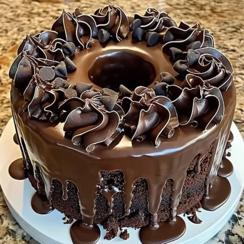 A slice of Death by Chocolate Cake topped with chocolate ganache and shavings