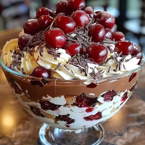 Delicious cherry chocolate trifle layered with cherries and chocolate cream.