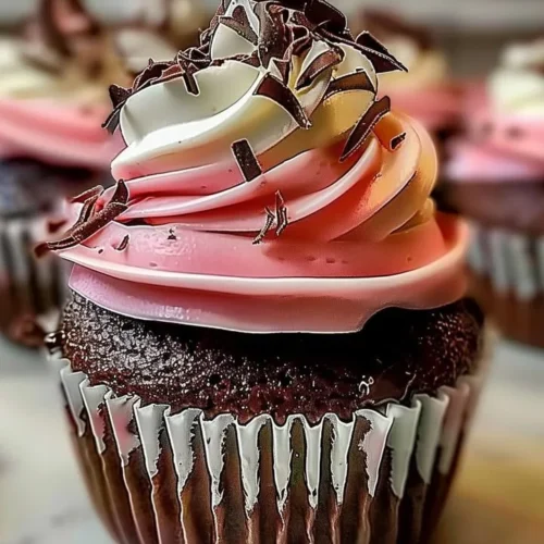 Decadent Neapolitan cream cupcakes with chocolate, vanilla, and strawberry layers.