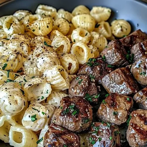 Garlic butter steak bites served with creamy Parmesan pasta shells on a plate