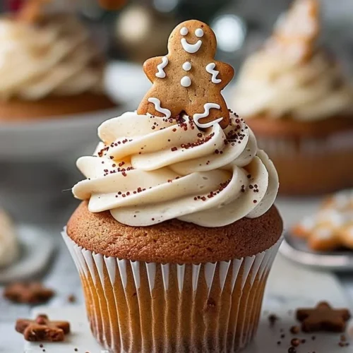 Delicious gingerbread cupcakes topped with creamy frosting and festive decorations.