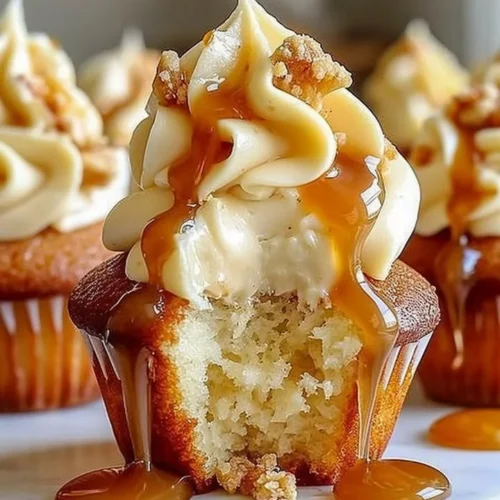 Gooey salted caramel cream cheese cupcakes topped with drizzled caramel sauce.
