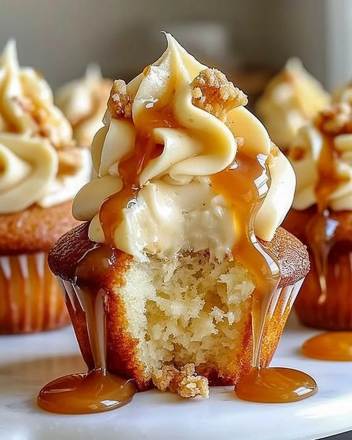 Gooey salted caramel cream cheese cupcakes topped with drizzled caramel sauce.