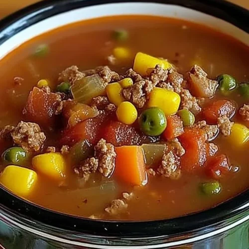Heart Crock Pot Cowboy Soup with vegetables and meat in a slow cooker.
