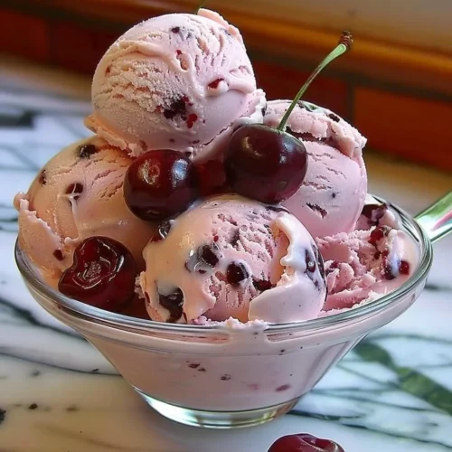 Bowl of homemade cherry ice cream topped with fresh cherries
