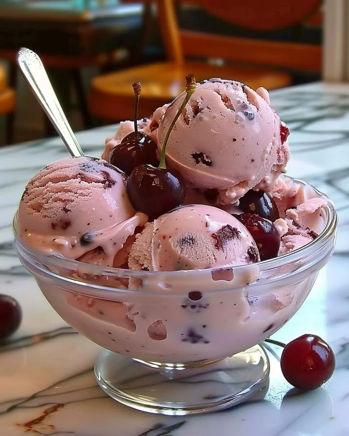 Bowl of homemade cherry ice cream topped with fresh cherries