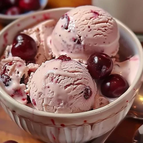 Homemade cherry vanilla ice cream in a bowl garnished with cherries