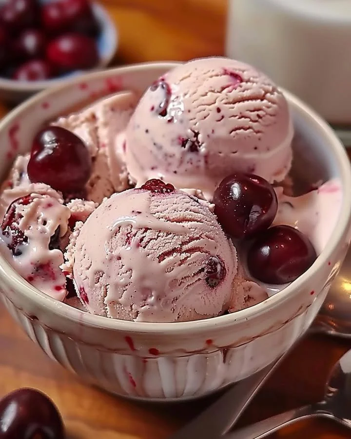 Homemade cherry vanilla ice cream in a bowl garnished with cherries
