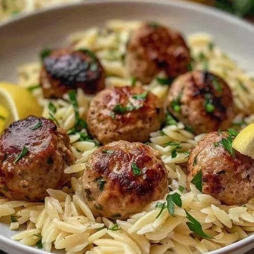 Plate of lemon chicken ricotta meatballs served with garlic orzo.