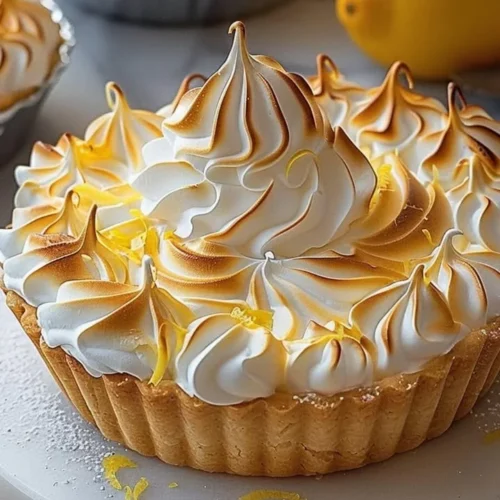 Lemon Meringue Tart with golden meringue topping on a white plate