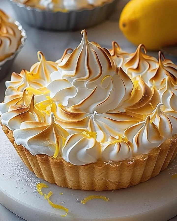 Lemon Meringue Tart with golden meringue topping on a white plate
