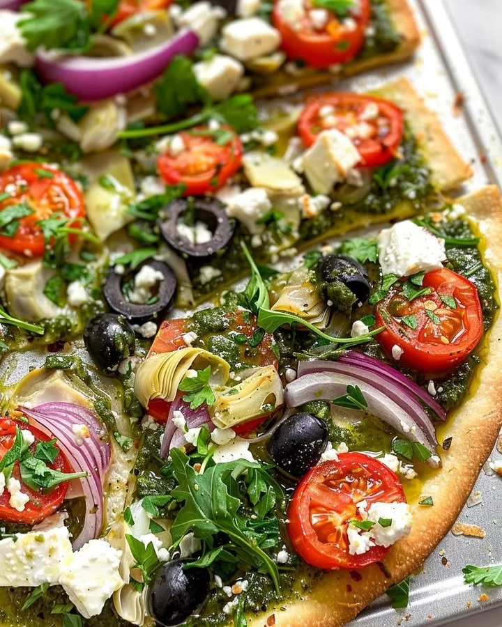 Mediterranean veggie flatbread topped with fresh vegetables and herbs