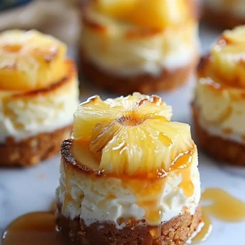 Mini Pineapple Upside-Down Cheesecakes topped with cherries and pineapple.