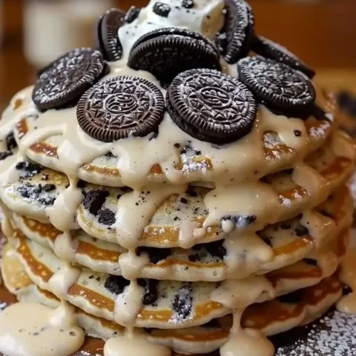 Delicious Oreo pancakes topped with cream cheese drizzle on a plate