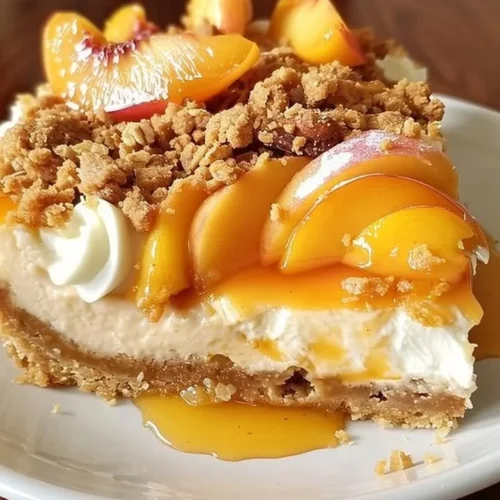 Piece of Peach Cobbler Cheesecake with fresh peach slices on top
