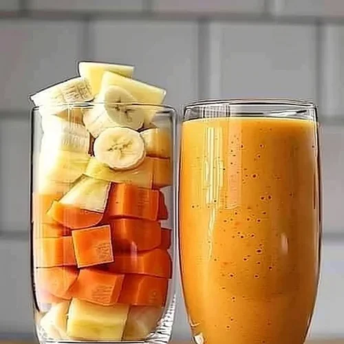 Pineapple Orange Carrot Smoothie served in a clear glass with a straw.