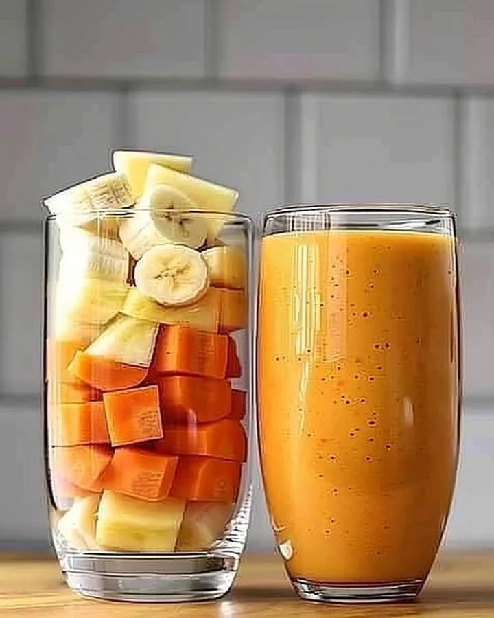 Pineapple Orange Carrot Smoothie served in a clear glass with a straw.