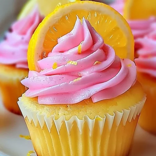 Delicious pink lemonade cupcakes decorated with lemon slices and pink frosting.