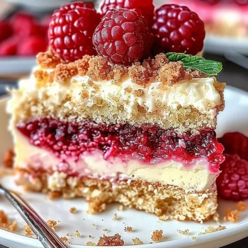 A slice of Raspberry Cream Cheese Coffee Cake topped with fresh raspberries.