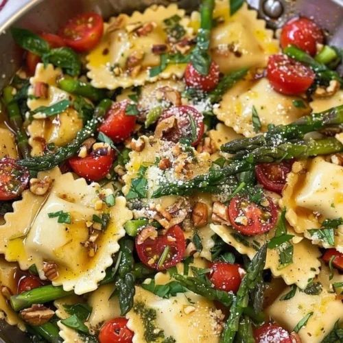 Delicious ravioli with tomatoes, asparagus, garlic, and herbs served on a plate