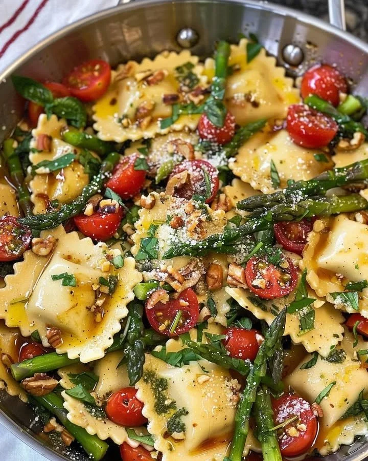 Delicious ravioli with tomatoes, asparagus, garlic, and herbs served on a plate