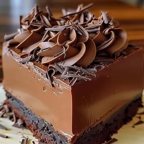 Rich chocolate mousse cake topped with chocolate shavings and fresh berries