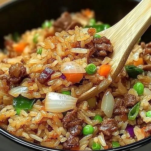 Plate of Savior Onion Beef Fried Rice garnished with green onions and herbs