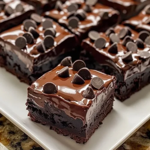 Decadent triple chocolate fudge brownies served on a plate.
