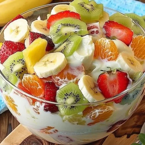 Tropical cheesecake fruit salad featuring colorful tropical fruits and creamy cheesecake.