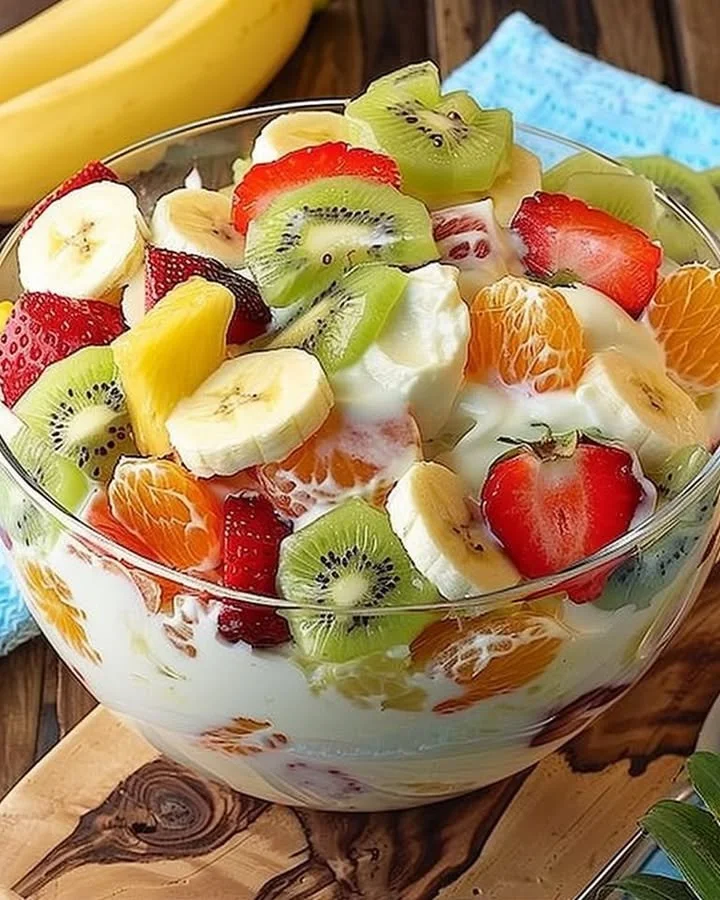 Tropical cheesecake fruit salad featuring colorful tropical fruits and creamy cheesecake.