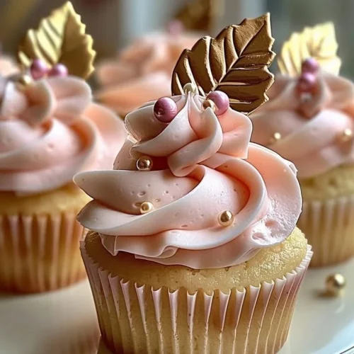 Vanilla cupcakes with blush pink buttercream frosting on a decorative plate