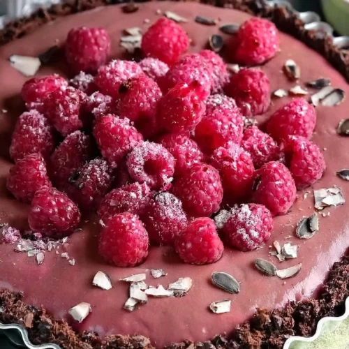Vegan Raspberry Chocolate Tart topped with fresh raspberries and chocolate drizzle