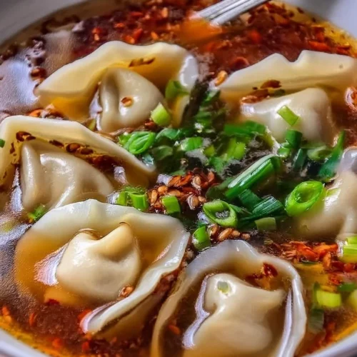 Delicious weeknight wonton soup served in a bowl with fresh herbs
