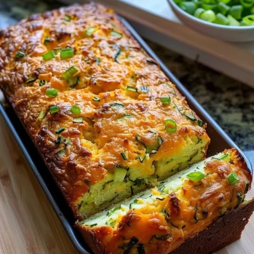 Freshly baked Zucchini Cheese Bread with cheese and green zucchini slices.