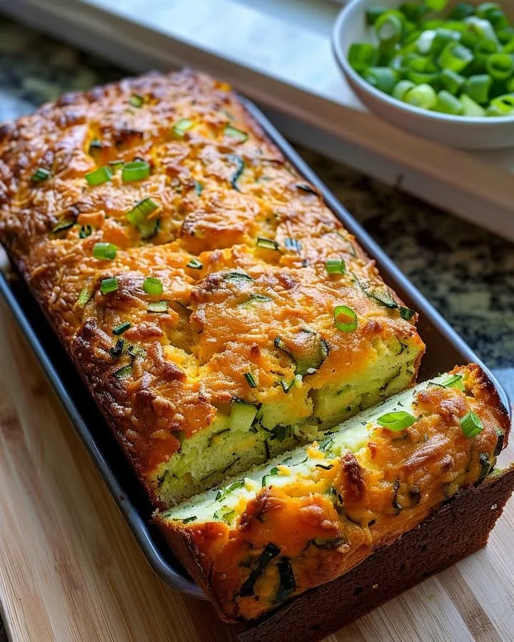 Freshly baked Zucchini Cheese Bread with cheese and green zucchini slices.